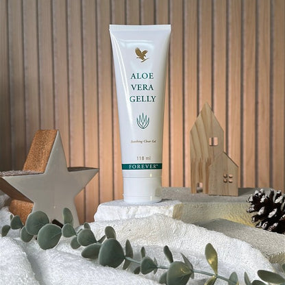 Tube of aloe vera gel on a decorative surface with greenery and wooden background