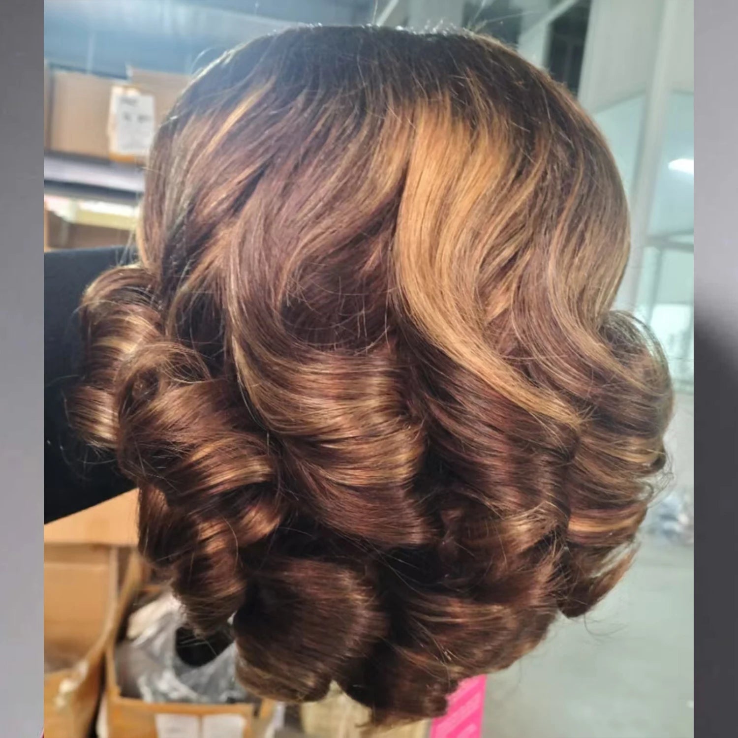Close-up of a styled hairdo with curls and highlights.