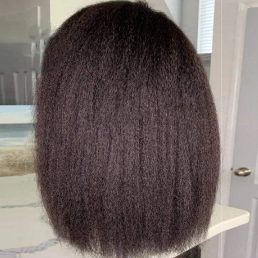Mannequin head with textured brown hair on a stand indoors.