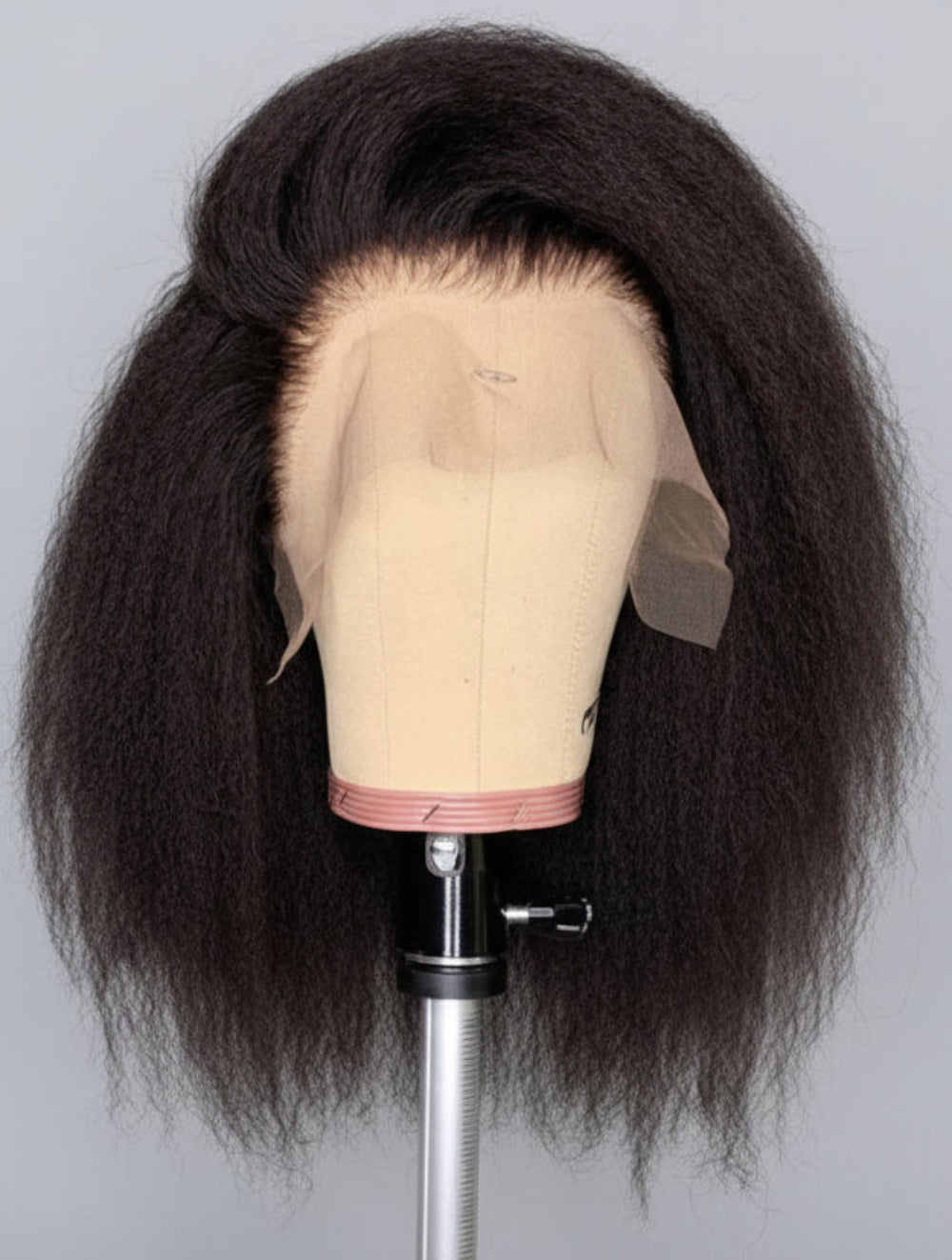 Kinky curly wig on a mannequin head with 'Fessenia' branding.